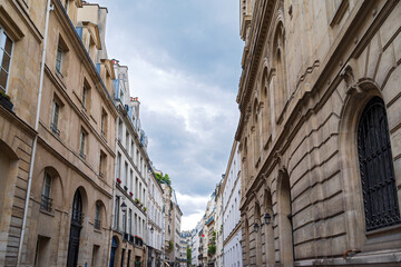 streetscape of commercial and residential buildings along rue des tournelles in marais district...