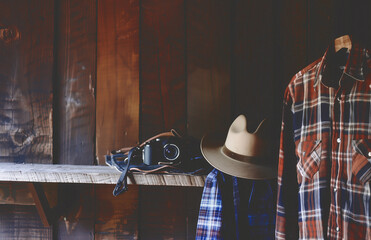 rugged cowboy and cowgirl clothes in a barn with a wooden background with a camera - 739636889