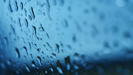 Raindrop on window blue background aqua bubble texture. Rainy water surface splash glass. Blurred...