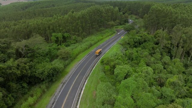 Truck passing on a beautiful road where there are many trees and beautiful landscape	