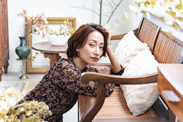 窓際に佇むワンピースを着た日本人女性