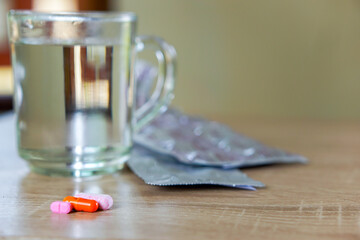 medicines and a glass of water on the table, for health concepts