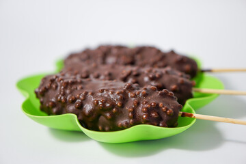 Chocolate ice creams on green plate isolated on white background