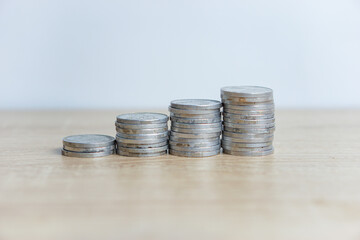 Foto close-up tumpukan koin di atas meja dengan latar belakang putih