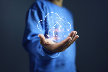 Man in a blue long sleeve shirt holds a cloud icon in his hand, symbolizing the use of cloud computing technology in everyday life