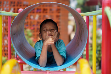 Asian little boy  playing in a children's playground in the city outdoors