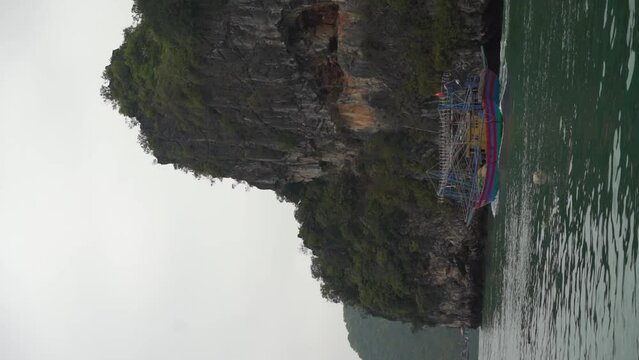 Traditional Thailand fishing vessel leaving for workday, vertical view