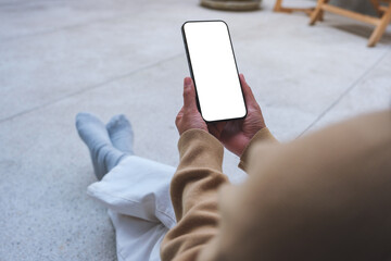 Mockup image of a woman holding mobile phone with blank desktop white screen