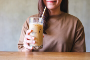 Closeup image of a young woman holding a glass of iced coffee