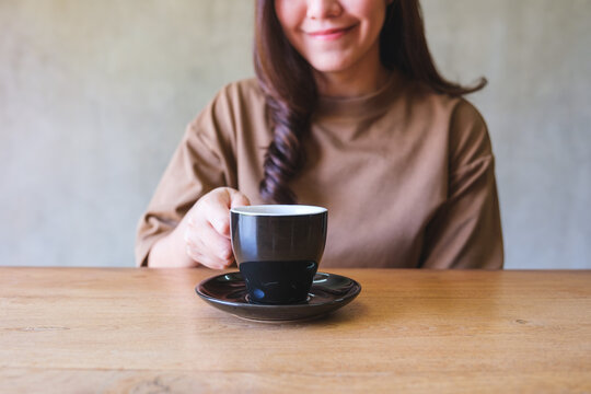 Closeup image of a woman holding and drinking coffee
