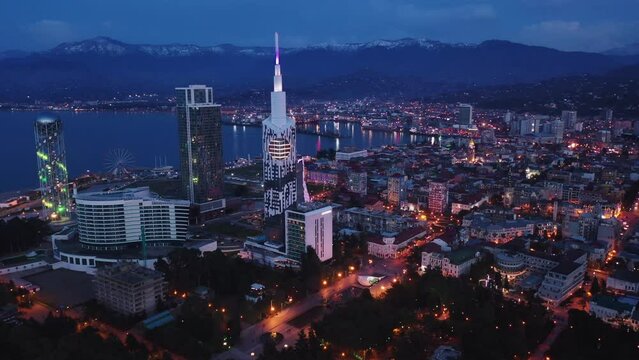 Scenic view from drone of seaside area of Batumi overlooking buildings of modern hotels and high-rise tower of Technological University on spring twilight, Georgia
