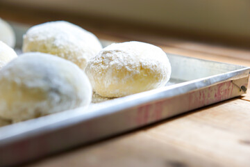 Small balls of fresh uncooked homemade donuts on a wooden table