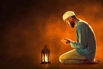 Young asian muslim man with beard praying in the mosque at dark night - 739687426