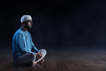Portrait of young asian muslim man with beard  sitting in empty mosque at dark night - 739690014