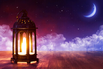 Shiny arabic lantern on wooden floor at beautiful blue night sky with cloud, stars and crescent moon, Ramadan kareem background