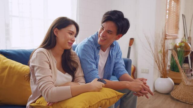 Asian young loving couple watch movie together in living room at home.