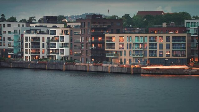 Modern residential buildings with brightly lit windows in the coastal quarter of the Kristiansand city.