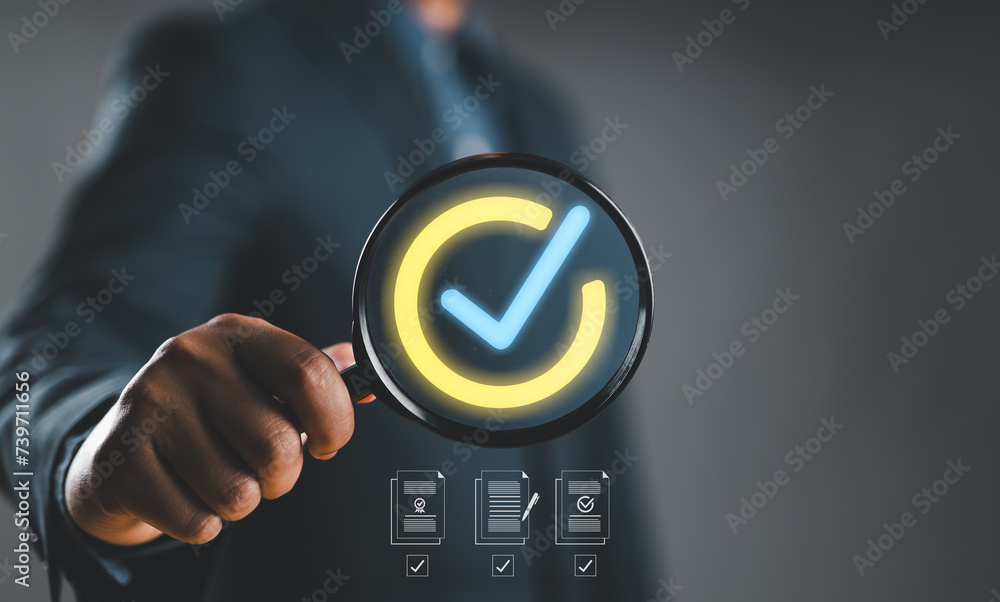 Poster Businessman hand holding magnifier glass for quality control concept, Quality management with Quality Assurance or QA and Quality Control or QC and improvement, Standardization and certification.