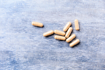 Lutein capsules. Dietary supplement on wooden background. Soft focus. Top view. Close up. Copy...