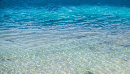 Fototapeta na wymiar Ocean sea texture with calm clear water of lagoon near shore of tropical island, copy space in blue