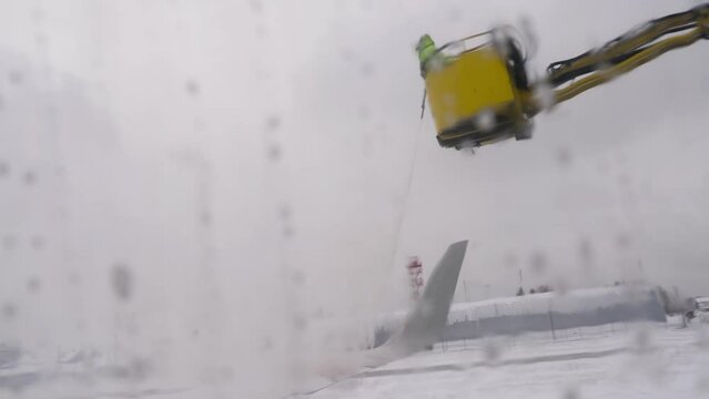 Deicing of passenger aircraft wing before flight. Winter frosty day at airport
