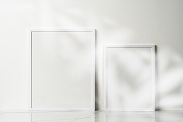 Blank wooden frame mock up on desk near white wall
