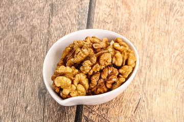 Cracked unshelled walnut in the bowl