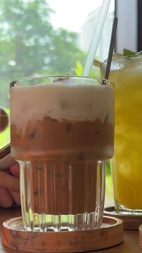 girl in gym is resting in cafe in hands with mobile phone. Pineapple juice Coffee Latte with salt Green tea with ice Buckwheat tea Three different drinks on the table healthy food choice juices