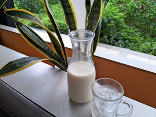 Photo of a bottle of soy milk with a glass