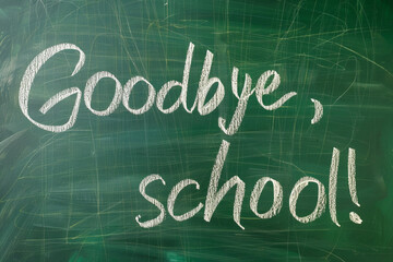 Goodbye, school! chalk inscription on a green blackboard.