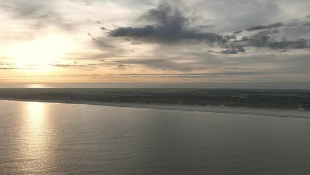 Aerial drone shot of the beach shore line of Ameland in the Netherlands during a beautiful sunrise