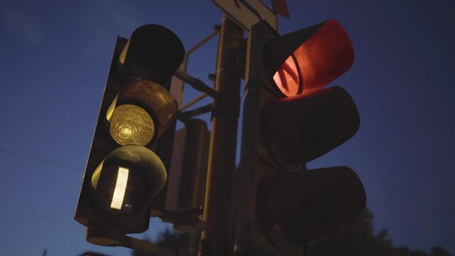 Traffic light at dusk with a glowing red signal and a light