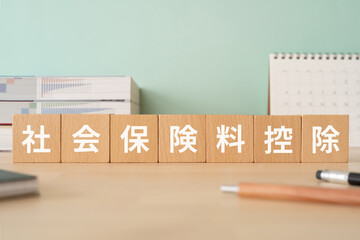 社会保険料控除の文字が入ったブロックが置かれたデスク