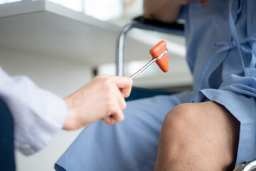 A doctor uses a reflex hammer to evaluate a patient's knee joint