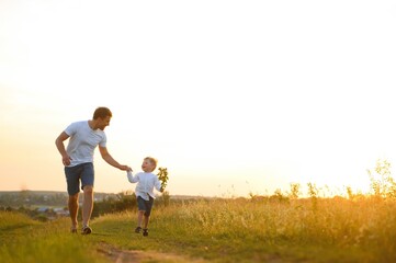 father's day. Dad and son playing together outdoors on a summer. Happy family, father, son at sunset.