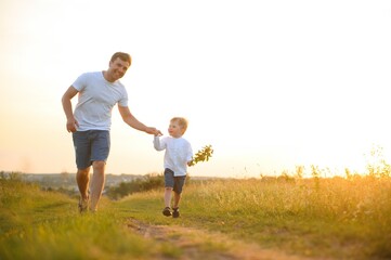 father's day. Dad and son playing together outdoors on a summer. Happy family, father, son at sunset.