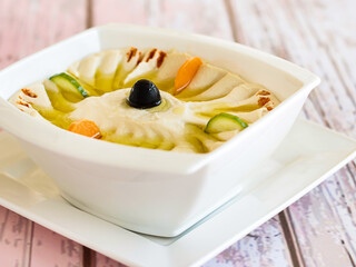 Hummus with Olive Oil, Carrot and Cucumber served in dish isolated on wooden table top view of cold mazza arabic food