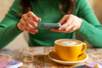 Woman drinking morning coffee and checking her phone, using mobile phone 