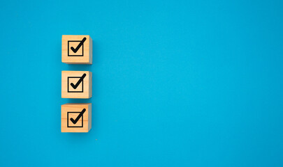 Three correct sign symbols on wooden cubes are over a blue background.