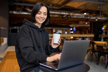 Cute woman working in coworking space with laptop
