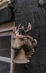 View of the old rusty doorbell with deer head decoration.