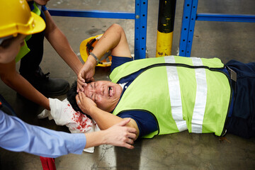 senior worker fell over and his head is bleeding on the floor in the factory