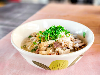 Shred chicken soup with noodles in bowl. Thai street food concept. ....