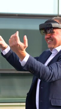 Businessman using virtual reality headset outside a financial building
