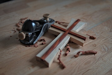 A planer and a wooden cross on a table, German handcrafts - obrazy, fototapety, plakaty