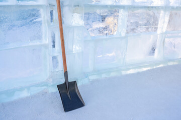 The steel shovel standing against ice wall