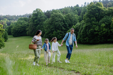 Family on interesting walk in forest, going through meadow. Mushroom, herbs medical plants or flowers picking, foraging. Concept of family ecological hobby in nature.