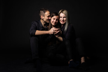 cute little girl and her beautiful young parents looking at camera and smiling