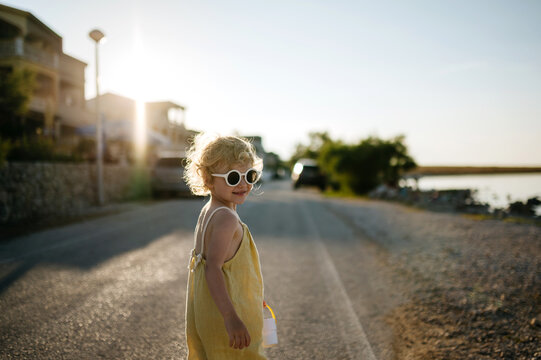 Portrait of blonde girl in summer outfit on walk during summer vacation, concept of beach holiday.