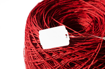Red raffia on a white background. Close-up of a skein of raffia.
